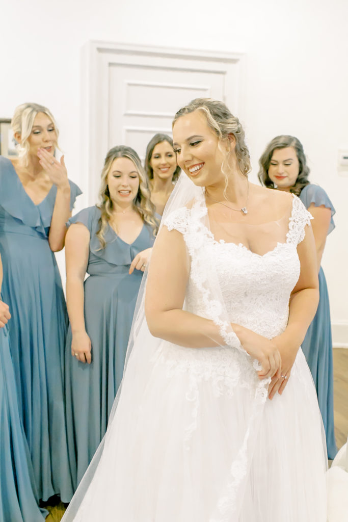 bride showing her bridesmaids the back of her dress