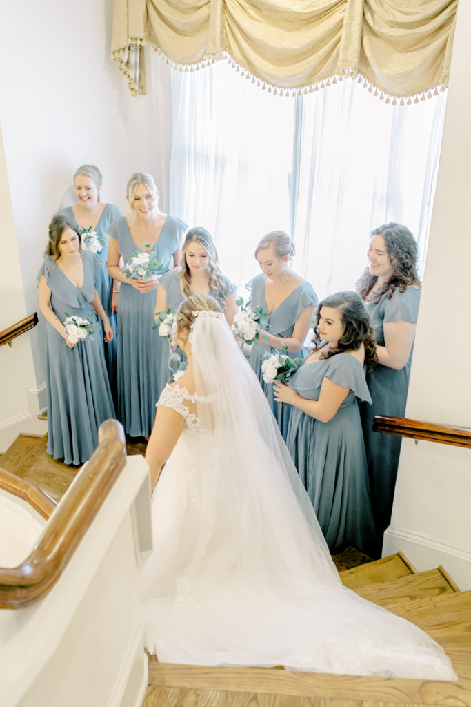 bride with bridesmaids on stairs