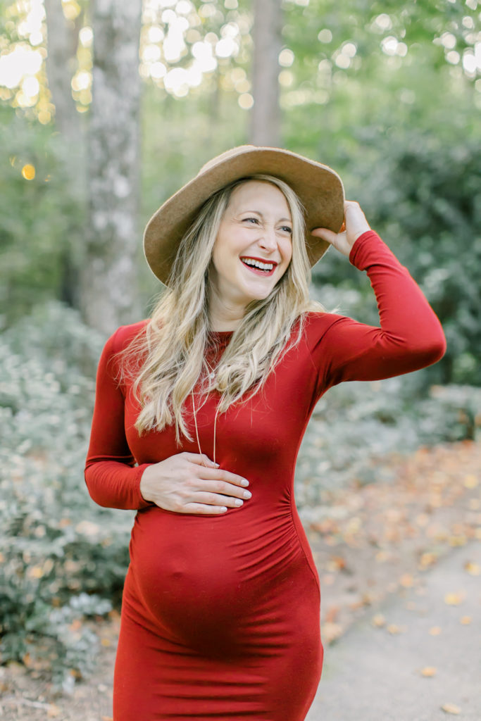 maternity session photo of mom holding hat and laughing
