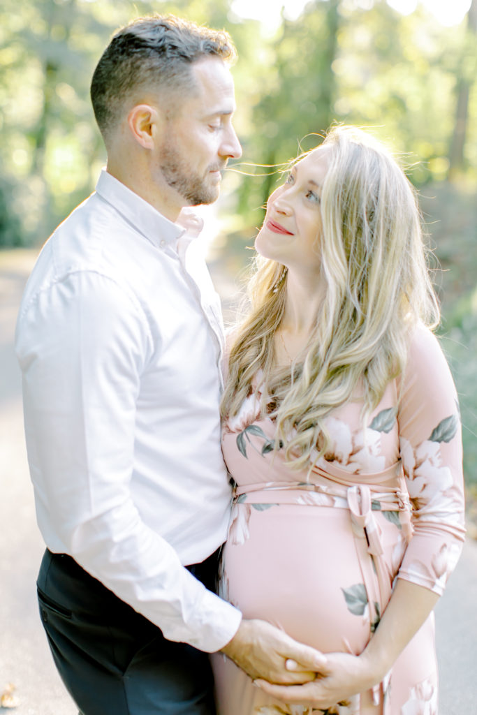 maternity photo of husband looking at wife and holding her belly
