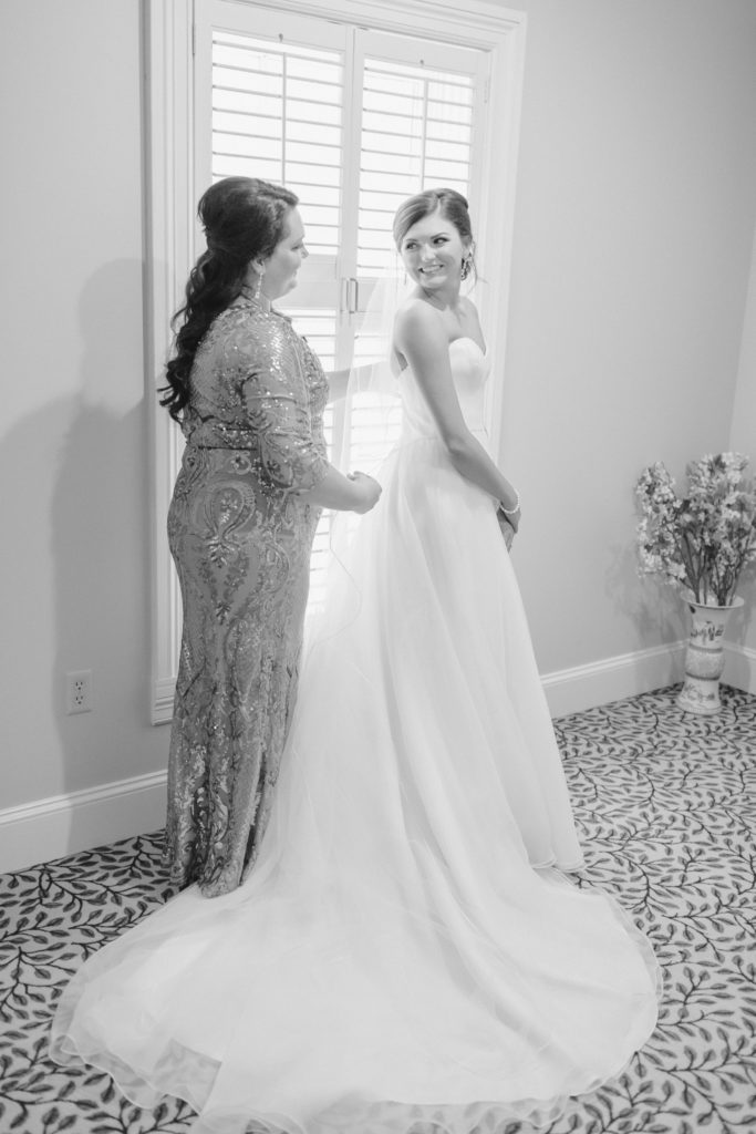 mom helping bride get in dress at the green valley country club in greenville south carolina