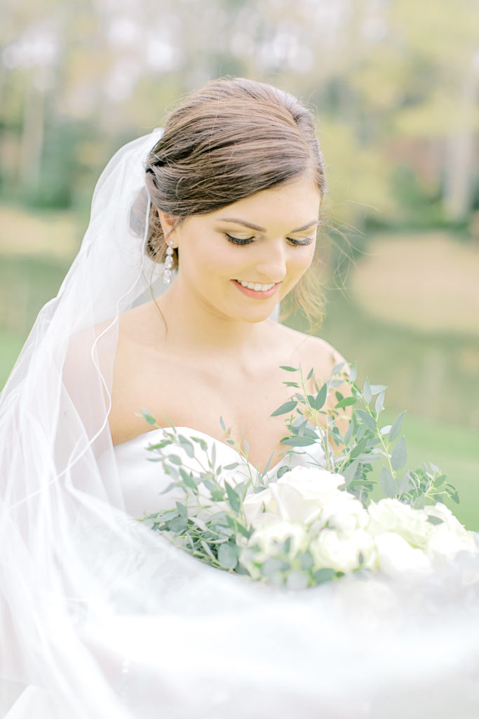 bride with veil around fowers