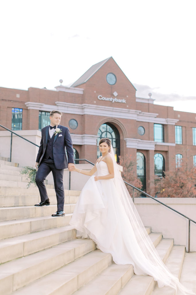 groom leading bride up steps of grace church downtown greenville