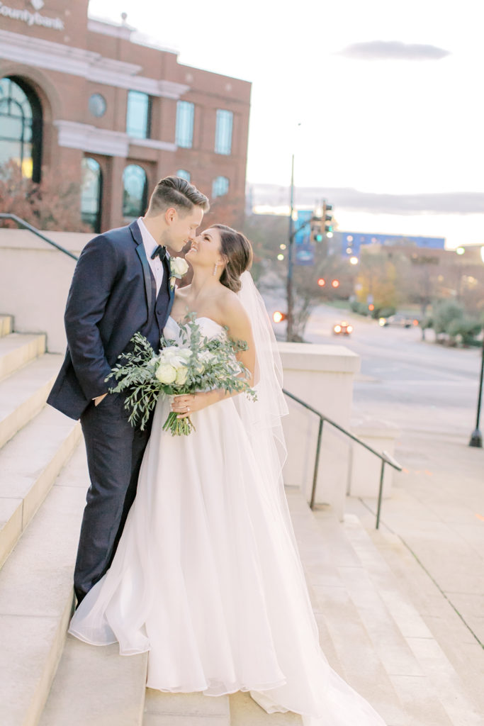 bride and groom kiss on the steps of grace church downtown greenville south carolina
