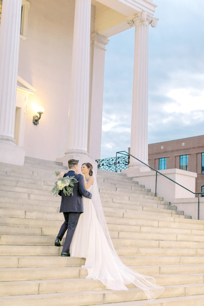 groom leading bride up steps of grace church downtown greenville