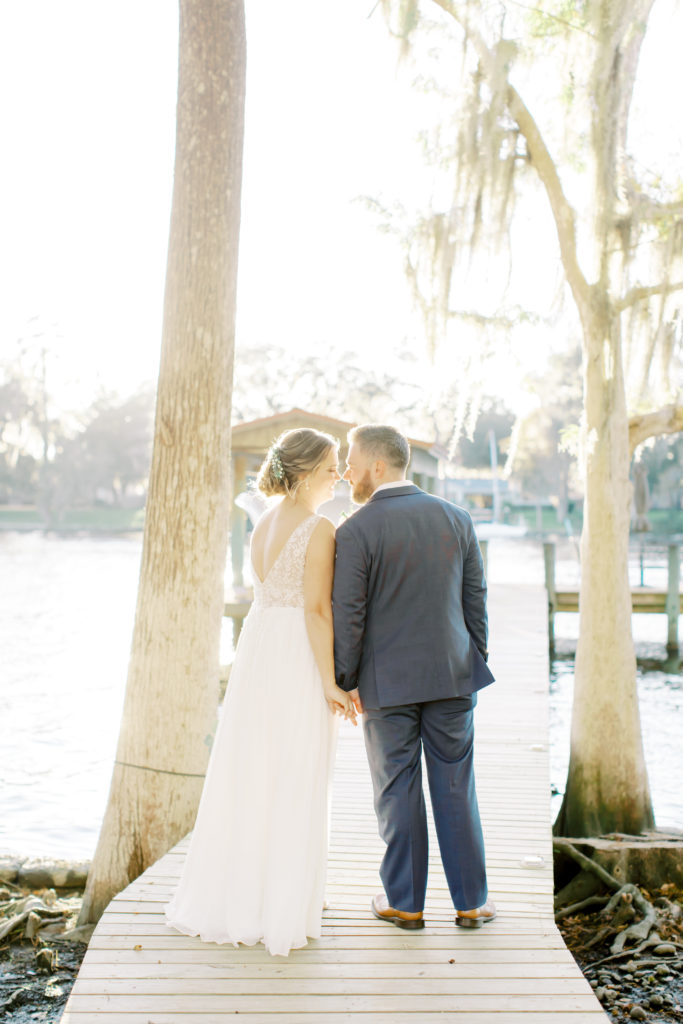 bride and groom walking on the dock out to the water.  Photo by Mary Catherine Echols