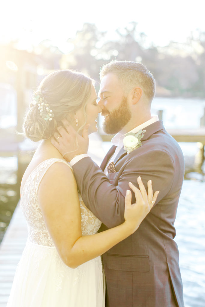 Bride and groom hugging and laughing on a dock.  Photo by Mary Catherine Echols