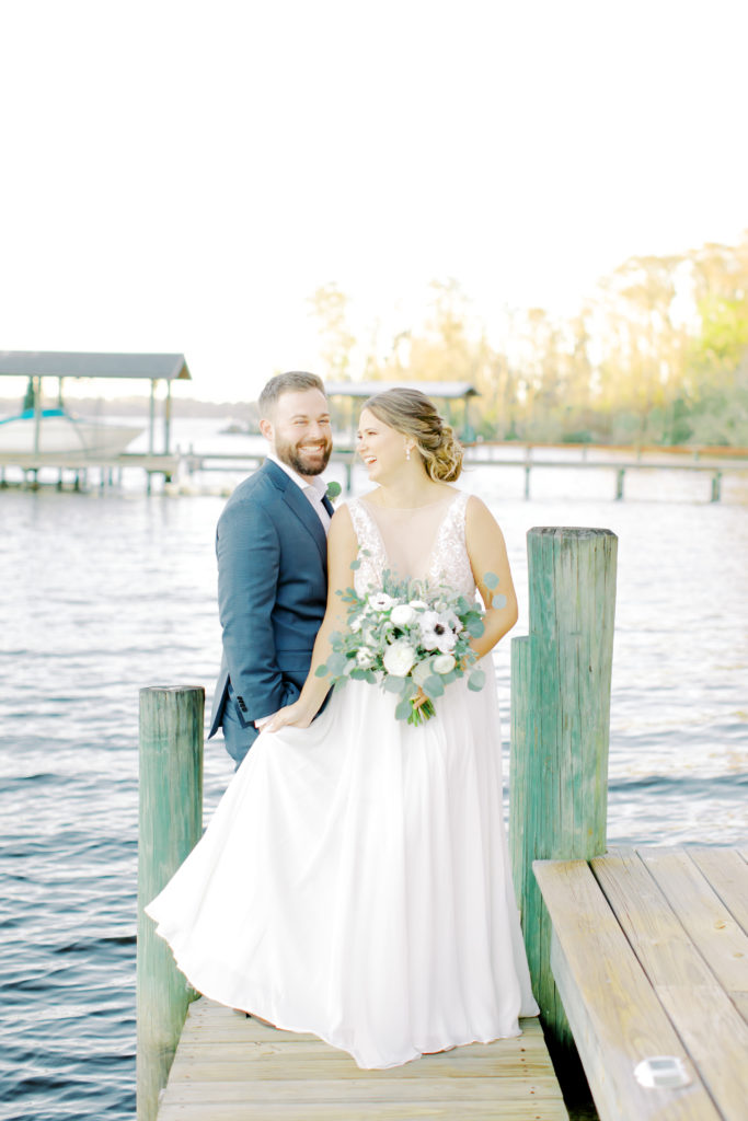 Bride and groom laughing while dancing with each other on the dock. Jacksonville, Wedding Photographer | Photo by Mary Catherine Echols