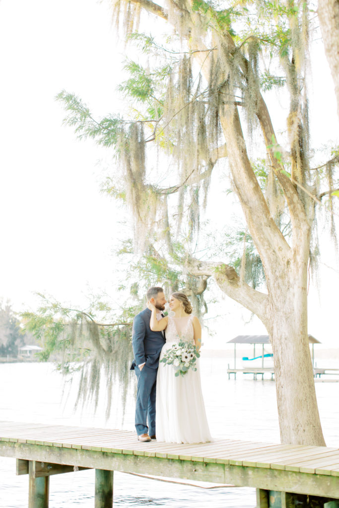 Bride cupping the grooms face, looking at each other on their family's dock in Flemming Island | Jacksonville, Wedding Photographer | Photo by Mary Catherine Echols