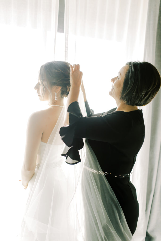 mom helping bride put on her veil | Photo by Mary Catherine Echols