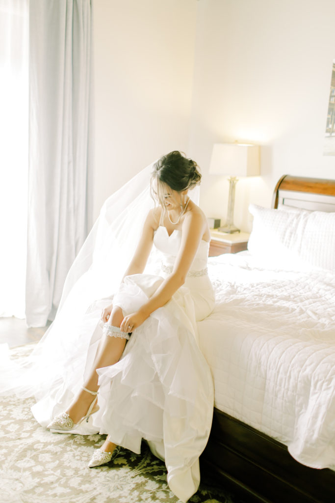 bride putting on her garter | Photo by Mary Catherine Echols