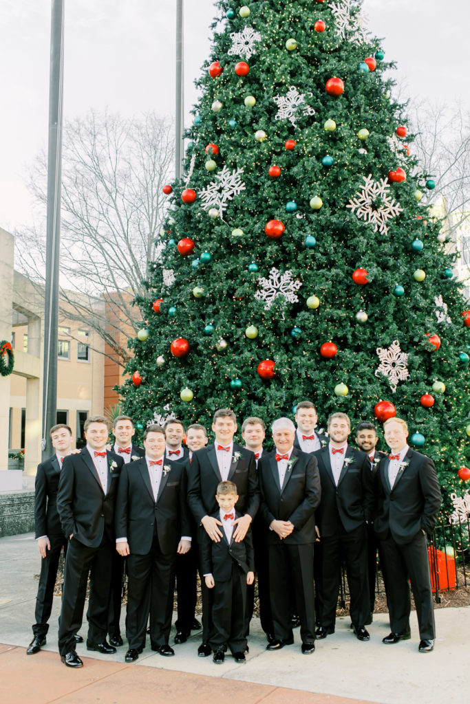 groom and groomsmen in front of the christmas tree | Photo by Mary Catherine Echols