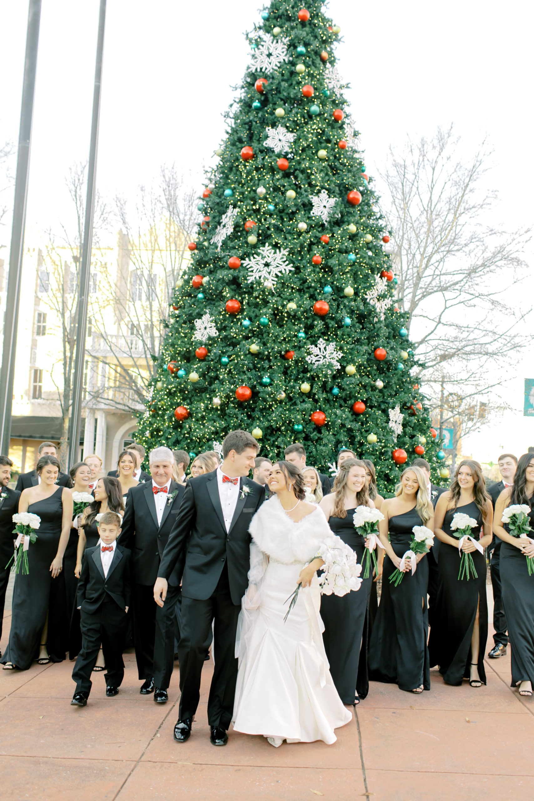 bridal party walking by the christmas tree| Mr + Mrs Kinsey | South Carolina Christmas Wedding