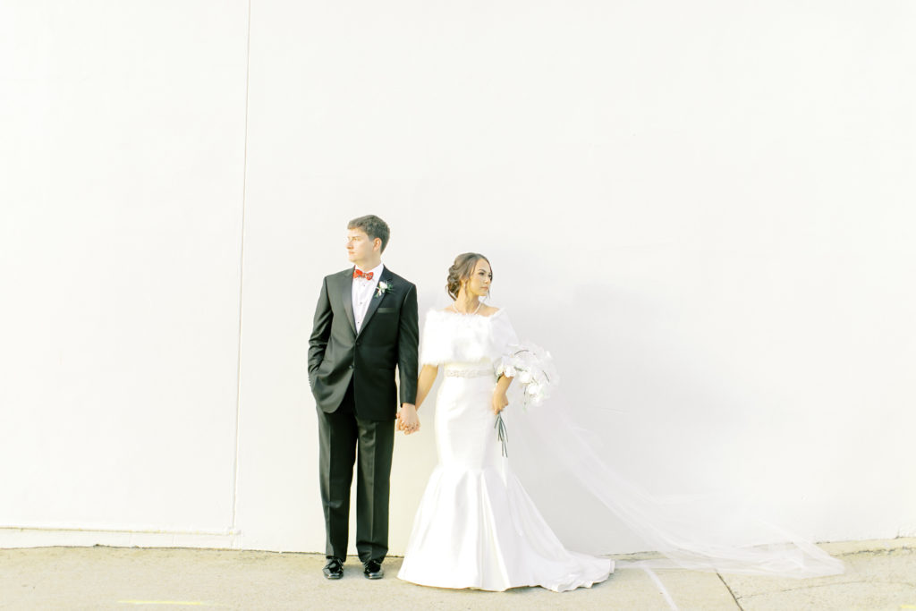 bride and groom hold hands by the wall of the bleclkey station in anderson south carolina | Photo by Mary Catherine Echols