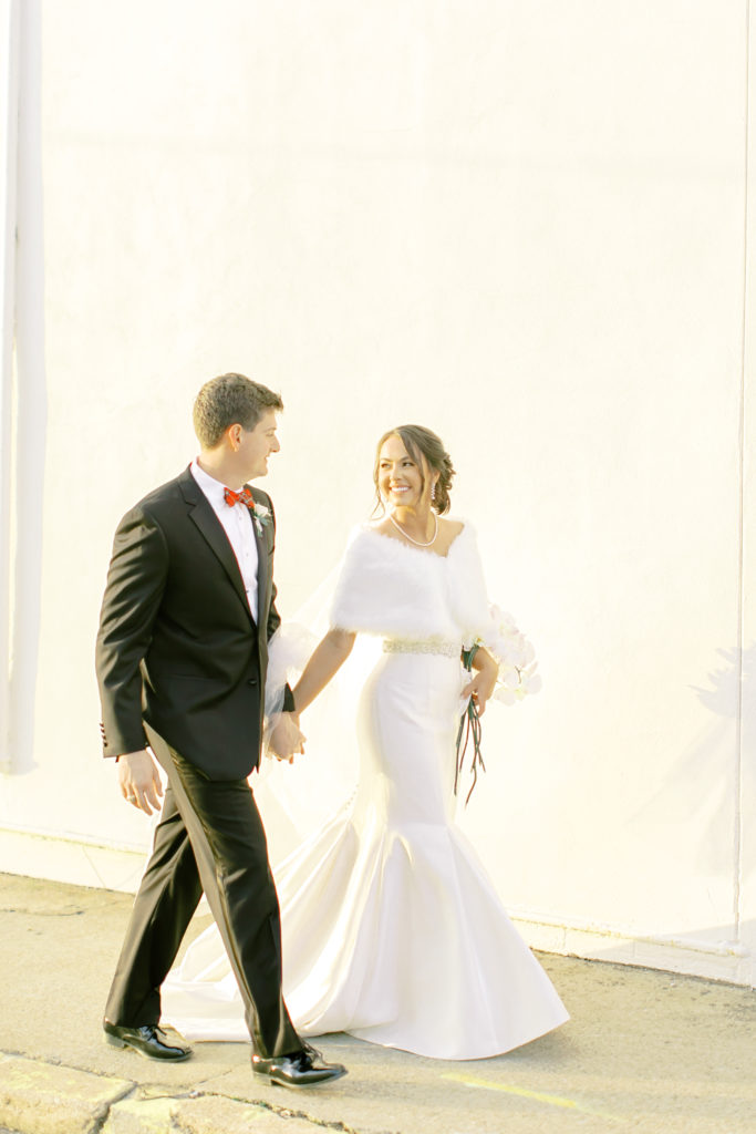 bride and groom walk downtown during their winter, christmas wedding | Photo by Mary Catherine Echols