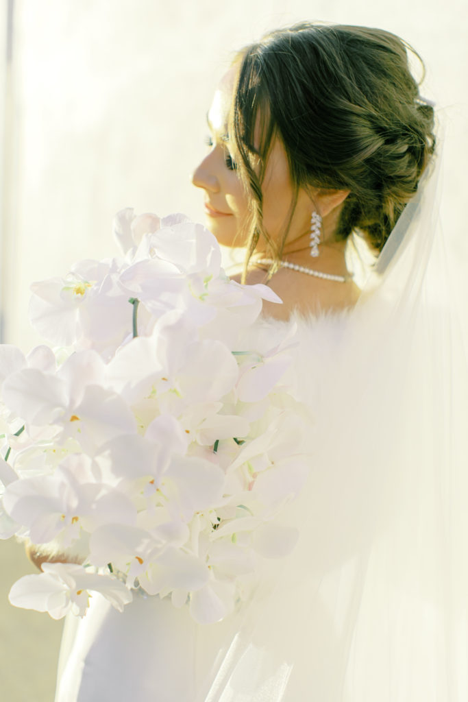 bride holding her orchid bouquet | Photo by Mary Catherine Echols