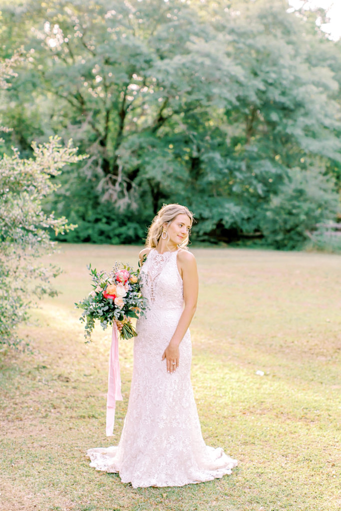 bride holding dress, looking off | photo by mary catherine echols