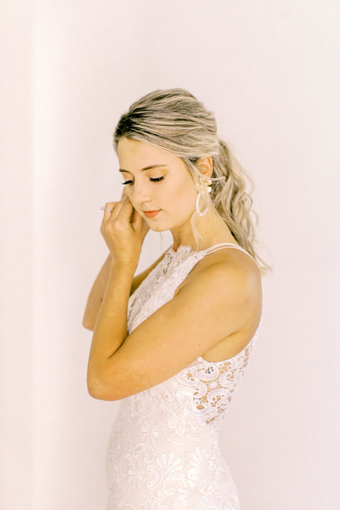bride putting on earrings at wavering place | photo by mary catherine echols