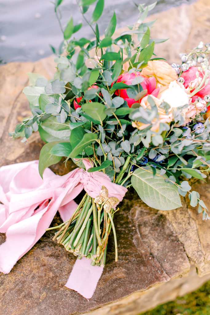 wedding bouquet laying by the fountain in front of wavering place | photo by mary catherine echols