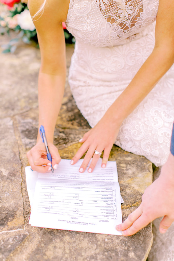 close up shot of bride signing marriage license | photo by mary catherine echols