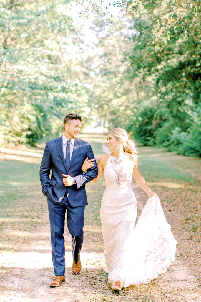 bride and groom walking and laughing, she holds her dress | photo by mary catherine echols