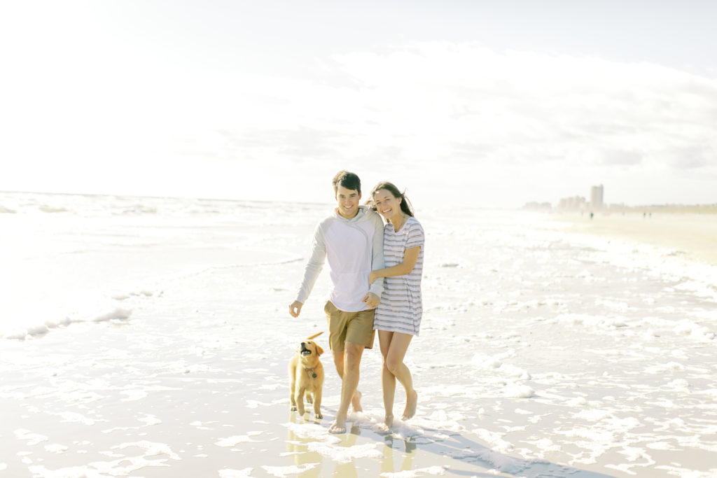 couple walking with their puppy on atlantic beach