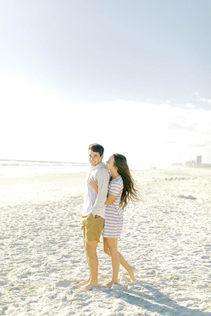 engaged couple hugging on neptune beach