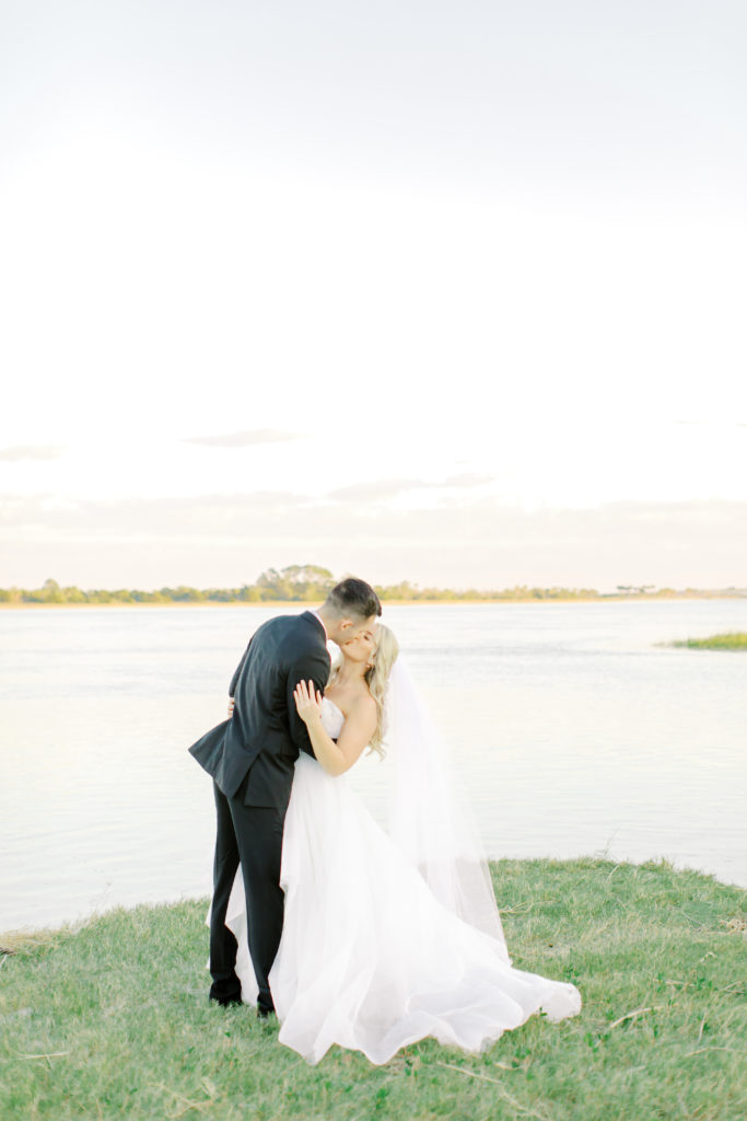 bride and groom kiss by the water at the ribault club | photo by Mary Catherine Echols, a Jacksonville based wedding photographer