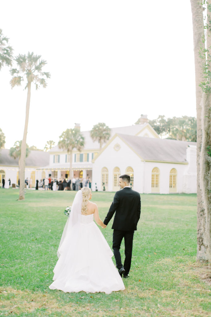 bride and groom walking back to their reception at the ribault club | photo by Mary Catherine Echols, a Jacksonville based wedding photographer
