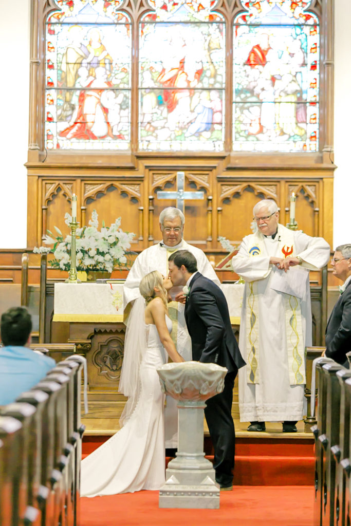 bride and groom first kiss in church