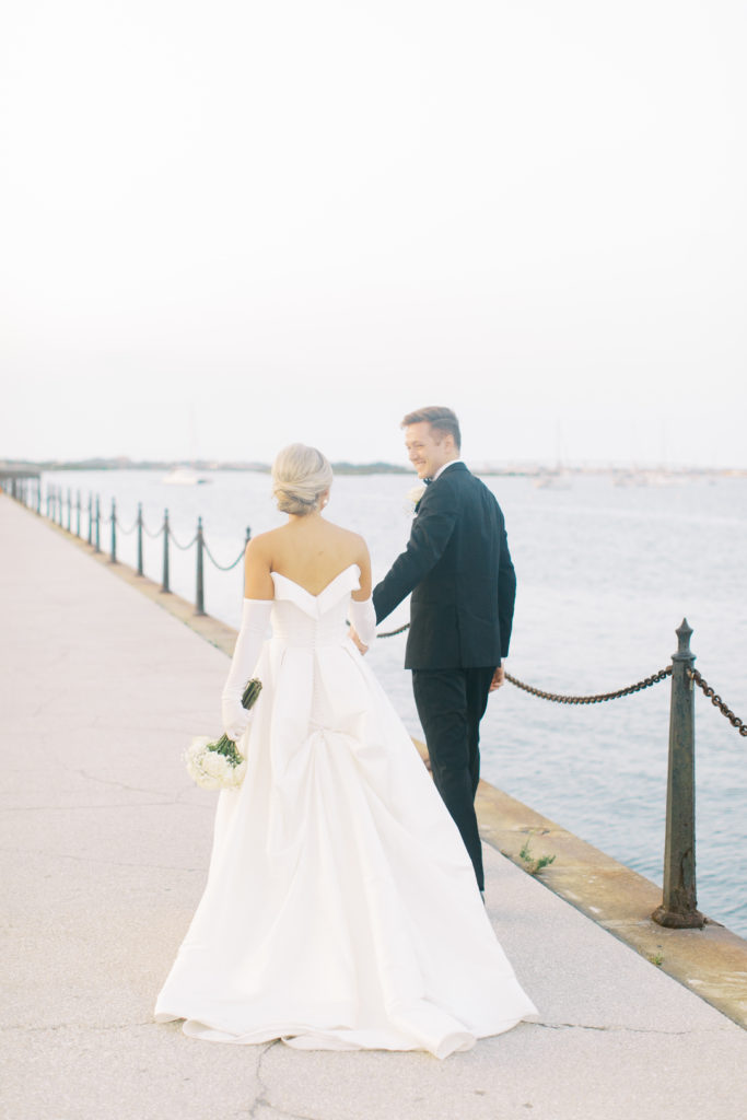 bride and groom walk by the water at wedding at treasury in st Augustine Florida